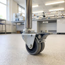 75mm twin wheel braked grey rubber bolt hole castor fitted to the tube leg of a laboratory equipment trolley