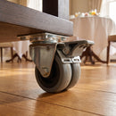 75mm twin wheel braked grey rubber top plate castor bolted under a hotel breakfast room serving trolley