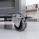 75mm twin wheel braked grey rubber top plate castor bolted under a steel mobile tool cabinet in a garage workshop