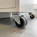 75mm twin wheel top plate castor with grey rubber wheels fitted under a white mobile storage cabinet