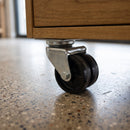 75mm twin wheel top plate castor under an oak mobile storage cabinet on a terrazzo floor