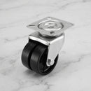 75mm twin wheel swivel top plate castor with black polypropylene wheels on light grey marble, 45 degree three-quarter view from a steep high angle