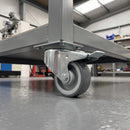 80mm braked swivel castor with grey polyurethane wheel under a steel workshop workbench