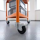 80mm black rubber braked bolt hole castor fitted to an orange steel trolley leg