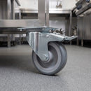 80mm braked top plate castor with grey TPR wheel under a stainless steel catering trolley in a commercial kitchen