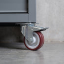 80mm braked top plate castor with maroon polyurethane wheel under a grey steel workshop tool cabinet