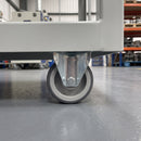 80mm fixed castor with grey polyurethane wheel under a grey steel industrial trolley