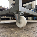 80mm swivel castor with white nylon wheel bolted with nuts under a steel industrial trolley