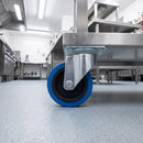80mm swivel top plate castor with blue non-marking rubber wheel bolted under a stainless steel catering trolley in a commercial kitchen