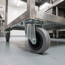 80mm swivel top plate castor with grey rubber wheel bolted under a stainless steel catering trolley