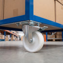 Braked swivel castor with white nylon wheel bolted under a blue warehouse cart