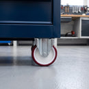Fixed castor with red polyurethane wheel under a blue steel workshop tool cabinet