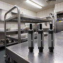 Round expanding castor tube adaptors on a stainless steel worktop in a commercial kitchen