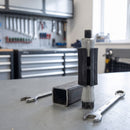 Square expanding castor tube adaptor next to a square steel tube and spanners in a workshop